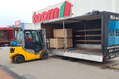 Gekaufte OSB-Platten werden mit Gabelstabler in den Hänger geladen.